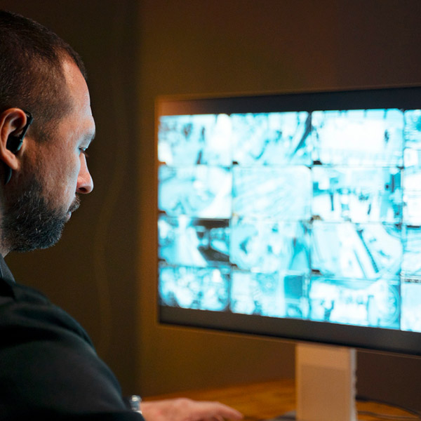 Profesional de seguridad realizando vigilancia a través de una pantalla con la imagen de cámaras